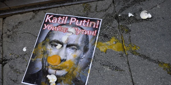 O fotografie cu Vladimir Putin este murdară de ouă aruncate în timpul unui protest împotriva intervenţiei ruseşti din Siria. FOTO AP