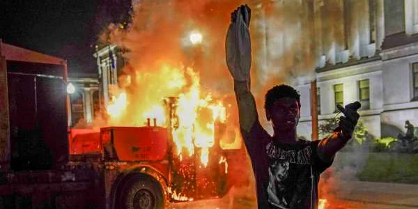 Protestatar în faţa unei maşini de gunoi incendiate în Wisconsin după ce un bărbat de culoare a fost împuşcat 24 august 2020 FOTO EPA-EFE