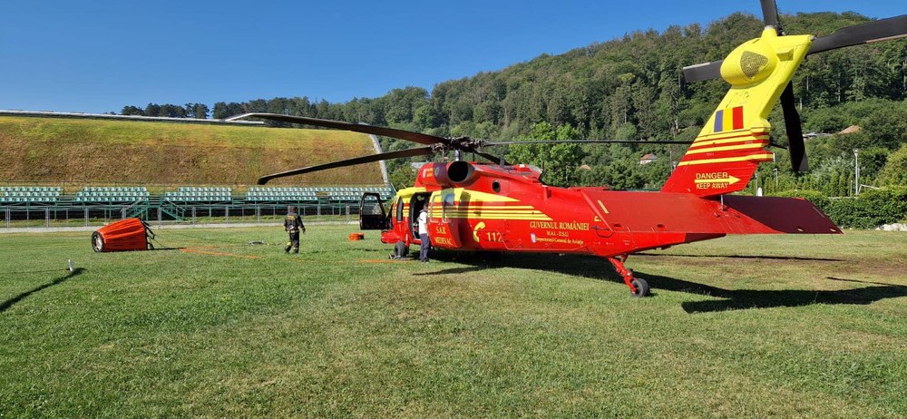 Un elicopter Black Hawk intervine să stingă un incendiu de vegetație uscată, într-o zonă stâncoasă și greu accesibilă