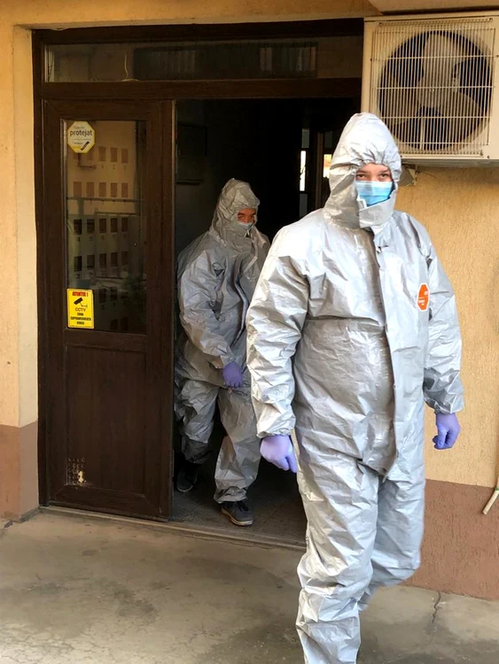 Cei care merg la casele persoanelor izolate poartă echipament de protecție