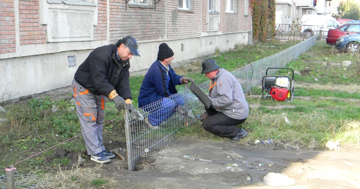 Muncitorii delimitează parcarea de zona verde