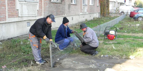 Muncitorii delimitează parcarea de zona verde