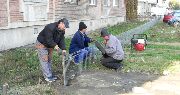 Muncitorii delimitează parcarea de zona verde
