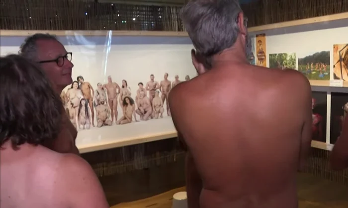 vizitatori dezbrăcați de haine la o expoziție de nudism