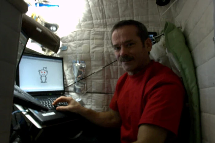 Canadianul Hadfield, în faţa laptopului cu simbolul Reddit pe el FOTO Twitter
