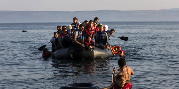 Doi emigranţi trag o ambarcaţiune supraaglomerată cu refugiaţi sirieni şi afgani care sosesc de pe coastele turceşti pe insula grecească Lesbos FOTO AP