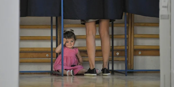 O fetiţă se odihneşte într o cabină de vot în timpul alegerilor pentru Parlamentul European dar si pentru Referendumul privind Justiţia în secţia de votare organizată la Liceul Jean Monnet din Bucureşti România FOTO Mediafax Andreea Alexandru  