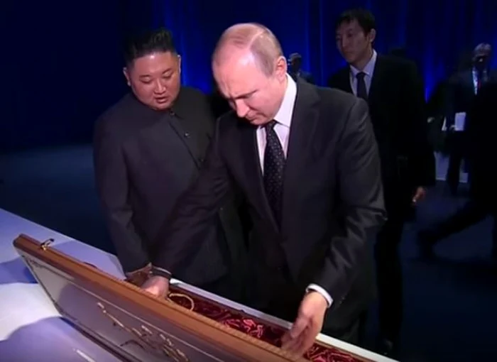 Vladimir Putin (primul din imagine) şi Kim Jong-un făcând schimb de cadouri la summitul de la Vladivostok Captură YouTube/RT