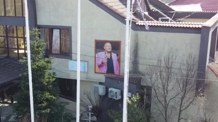 Primarul Jean Rogoveanu, omagiat cu paharul în mână pe fațada primăriei / foto: captură video