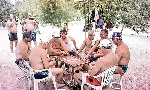 Grecii stau la plajă şi joacă table  fără nici o grijă jpeg