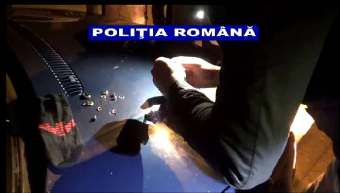 Poliţiştii scot dintr-o şosetă  aparţinând unuia dintre suspecţii de furt o parte din bijuteriile furate Foto: captură video IPJ Galaţi