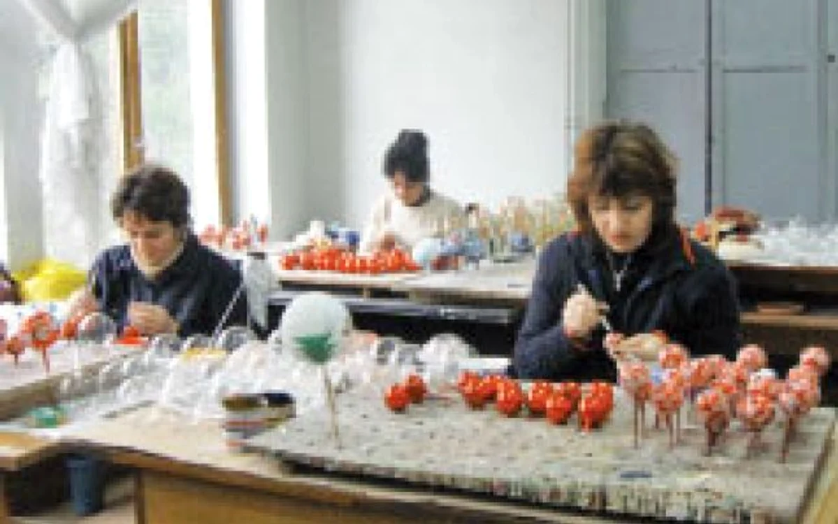Femeile desenează modele pe sfere din sticlă  