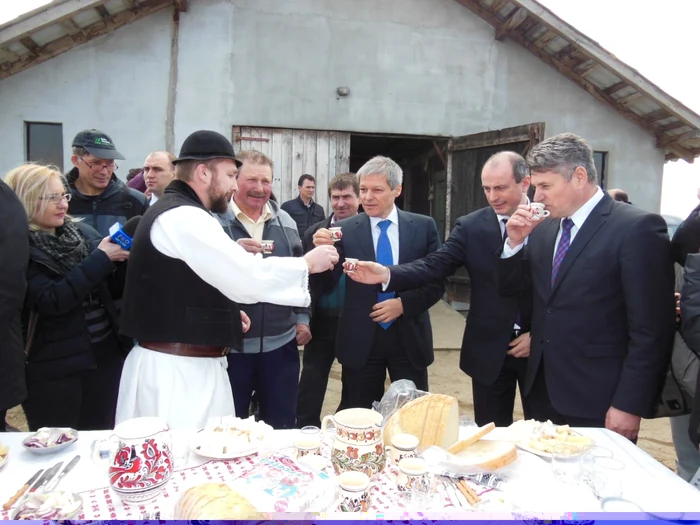 Premierul Dacian Cioloş a închinat un pahar de ţuică cu primarul din Ciugud, ministrul Agriculturii şi proprietarul unei ferme de vaci. Foto: Dorin Ţimonea