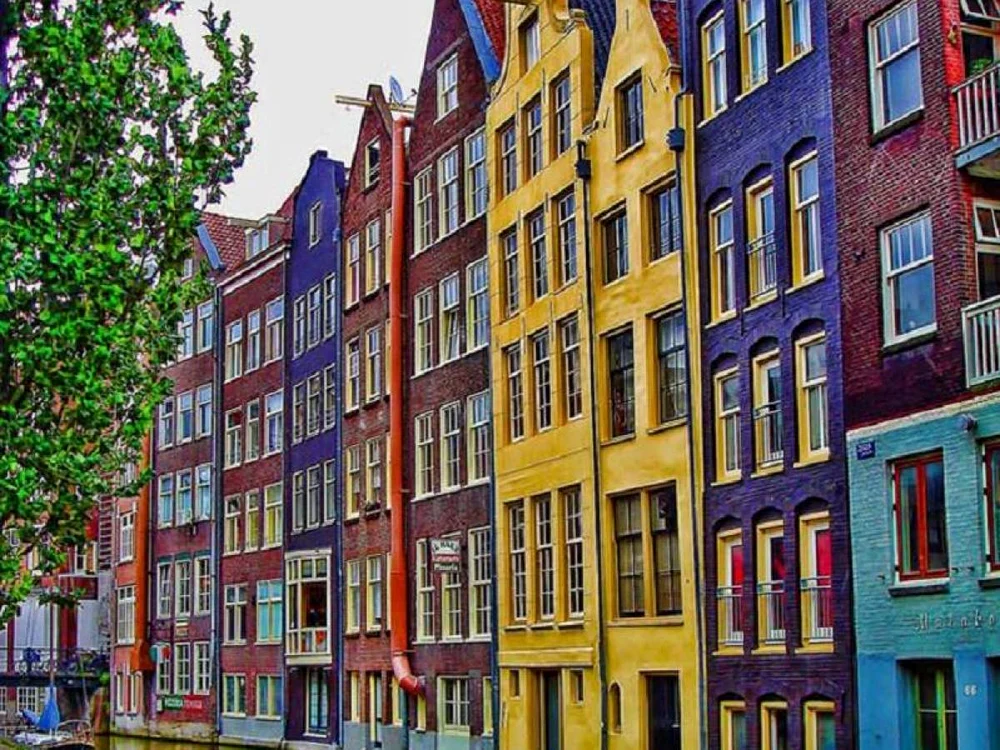 Amsterdam, Olanda. Clădirile de pe malul canalului ce străbate oraşul aduce aminte de arhietctura clasică olandeză.