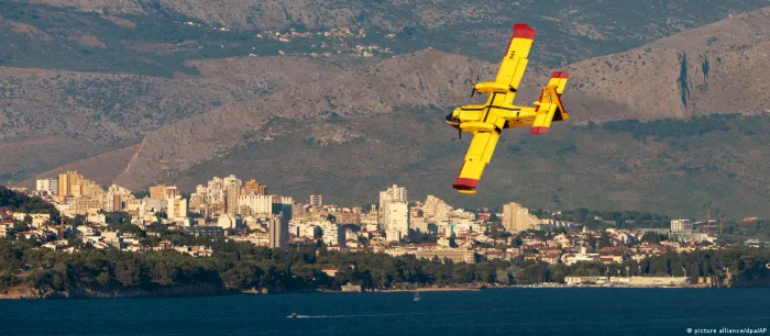 Un avion de stingere a incendiilor aterizează pentru a se reaproviziona cu apa 