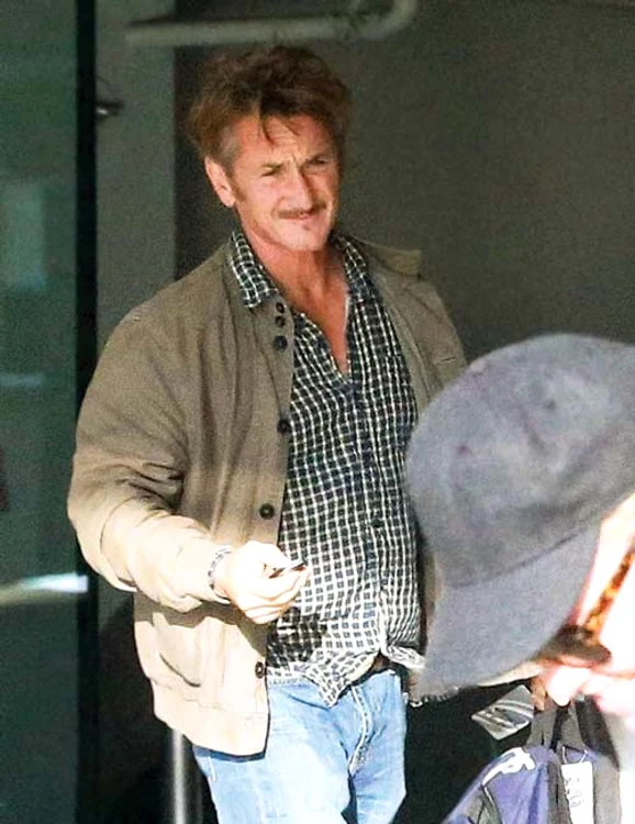 Într-un colț, Sean Penn o privește răbdător