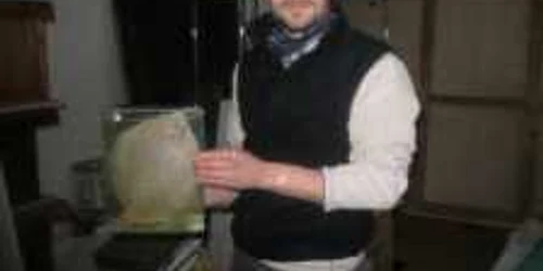 Biologul Sike Tamas ţine în mâini un acvariu cu un calcan în formol