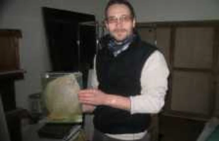 Biologul Sike Tamas ţine în mâini un acvariu cu un calcan în formol