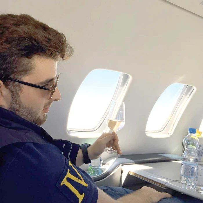 
    În avionul personal, Victoraş se răsfaţă  cu băuturi fine  