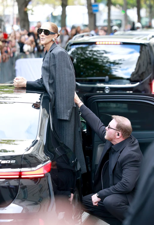 Céline Dion, sprijinită de bodyguardul ei în fața unui hotel 