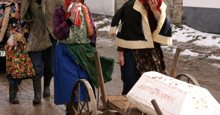 Sicriul alb este însoţit de alaiul colorat pe uliţele satului Foto: Mihai Lazăr