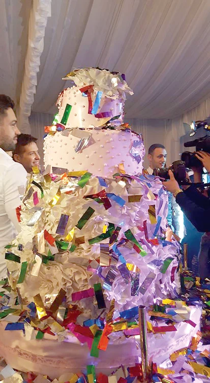 O ploaie de confetti pe tortul decorat cu mărgele albe