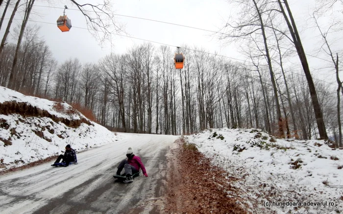 Telegondola din pasul Vulcan. Turiştii folosesc şoseaua ca pârtie de săniuş, în lipsa altor oportunităţi. Foto: Daniel Guţă. ADEVĂRUL