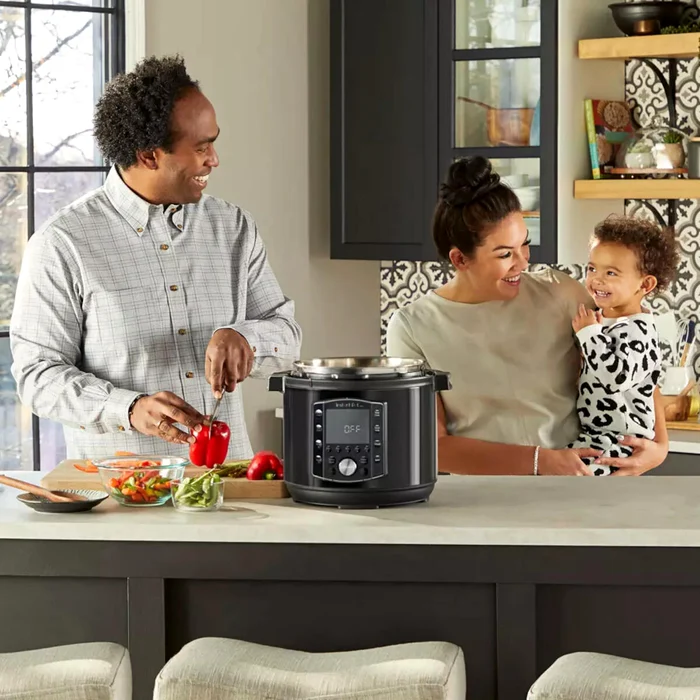 Familie tânără gătește împreună fericită folosind un multicooker Instant Pot Foto Instant Pot