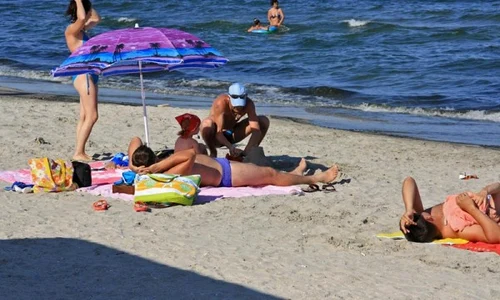 turisti la mare pe plaja jpeg