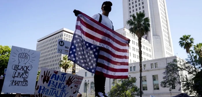 Protestar ţine steagul american invers în timpul unui marş paşnic faţă de moartea lui George Floyd  Los Angeles 3 iunie 2020 FOTO Warrick Page/Getty Images