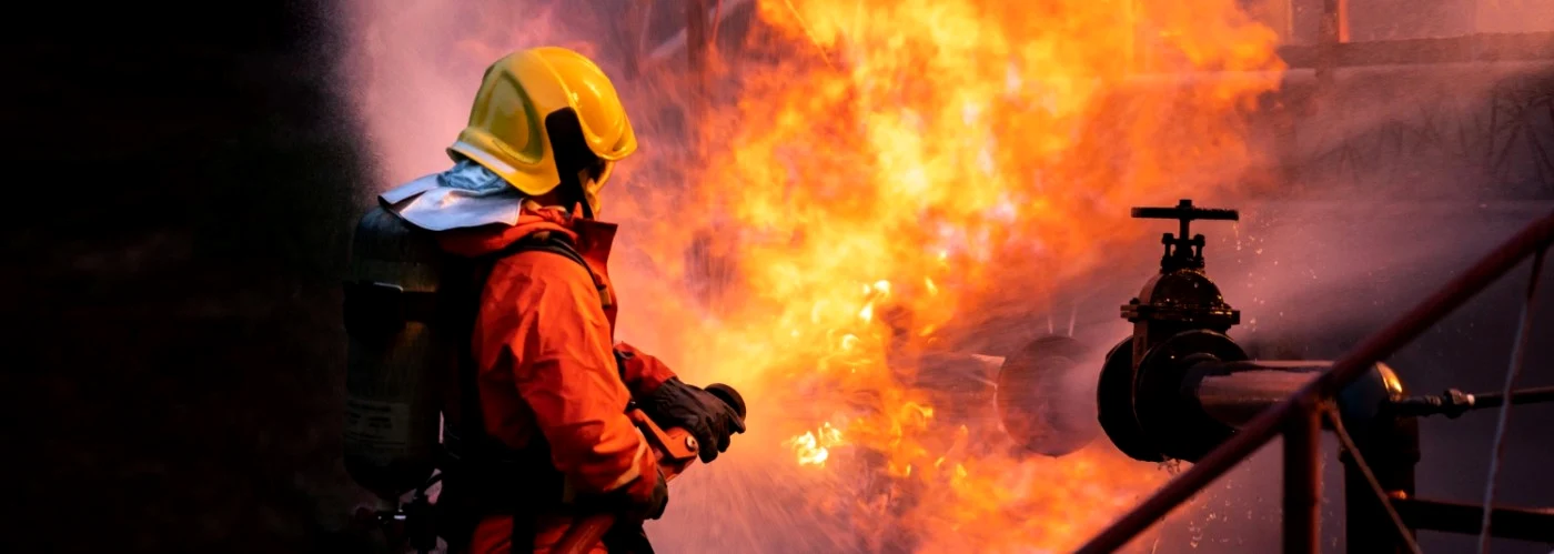 Un pompier încearcă să stingă un incendiu provocat de o explozie 