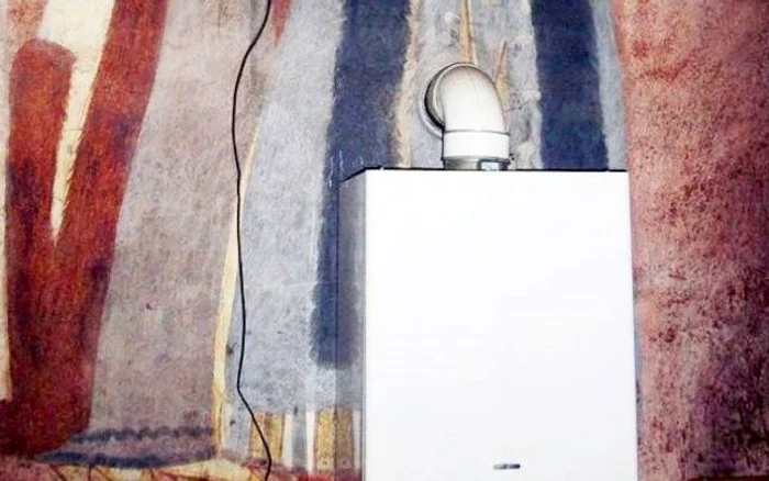 
    Un instalator  a montat o centrală termică exact pe pictura originală a doi dintre ctitorii Bisericii „Sfântul Nicolae“ din Târgu JiuFOTO: adevarul.ro  