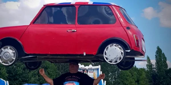 Un bărbat a devenit faimos pentru că a ţinut pe cap un automobil Mini Foto captură BBC