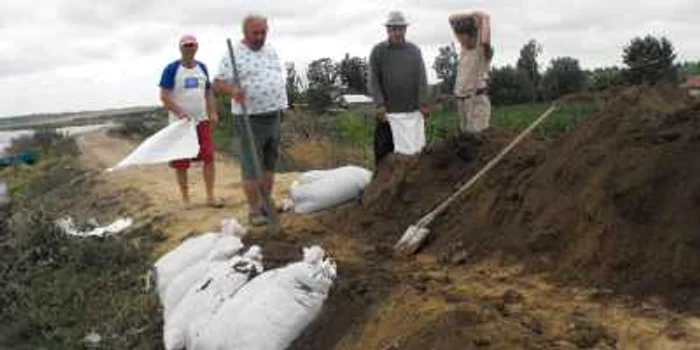 La inundaţiile din vară localnicii consolidau digul şi zi şi noapte foto arhivă