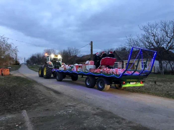 Moş Crăciun a venit cu un tractorul încărcat cu cadouri la copiii din comuna Berlişte