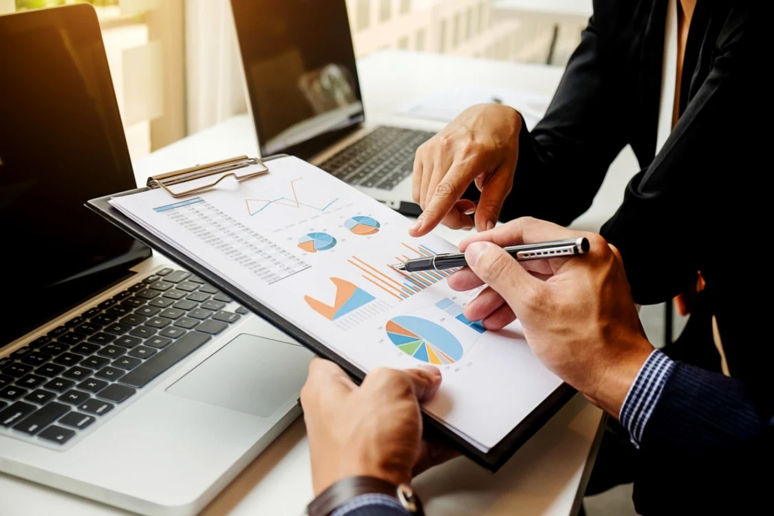 Doi analiști economici studiază niște grafice