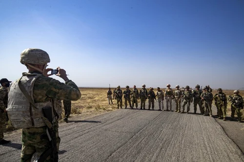  Soldații unui convoi militar rusesc și omologii lor americani s-au salutat în timp ce rutele lor de patrulare s-au intersectat pe un câmp petrolier din Siria FOTO AFP