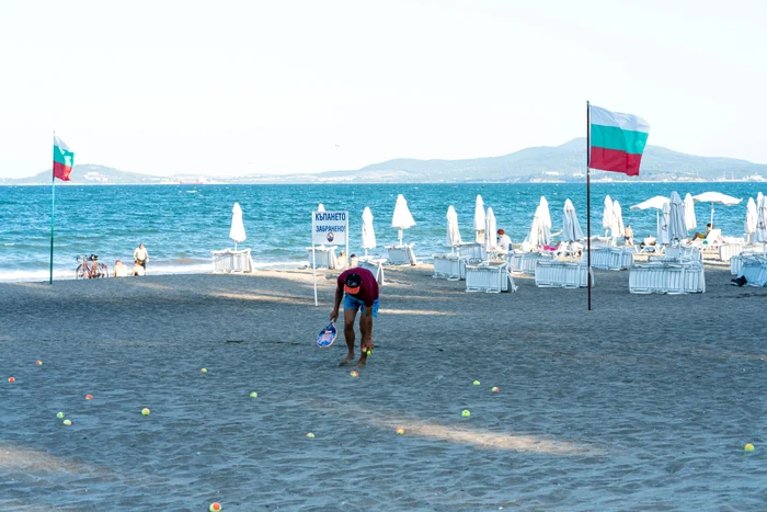 Un angajat strânge gunoaie de pe o plajă din Bulgaria