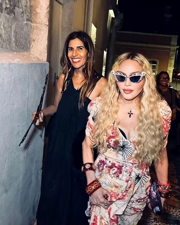 Madonna, îmbrăcată într-o rochie înfolartă și cu ochelari de soare la ochi, pe străzile din Lisabona