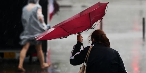 Meteo - vremea - ploi si vant - femeie cu umbrela FOTO Shutterstock 