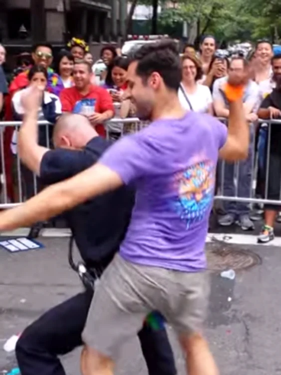 Un polițist american a început să danseze foarte sexy cu un bărbat de la parada gay, în New York.foto: captura video Youtube