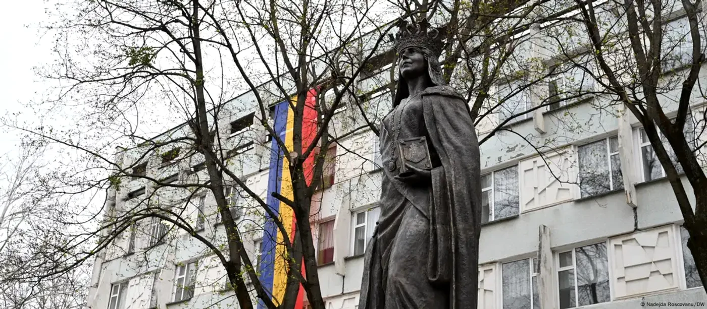 Un bloc de locuinţe pe stil sovietic în Chişinău. În faţa lui: statuia Reginei Maria.