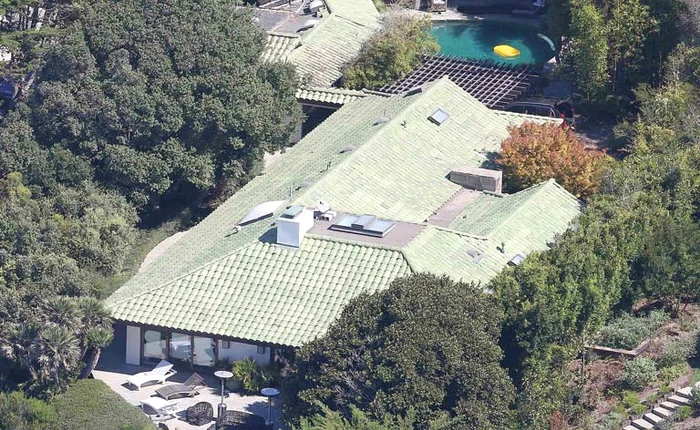 Casa e înconjurată de un gard de 3,5 metri şi copaci stufoşi