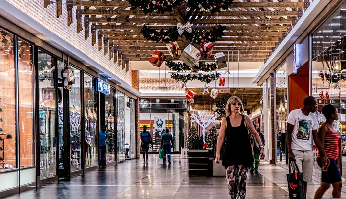 Un mall cu mulți oameni în fața magazinelor
