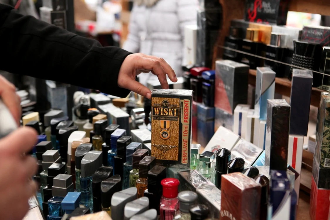 Un bărbat alege un parfum pe care scrie Wiski 