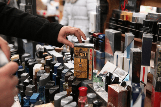Un bărbat alege un parfum pe care scrie Wiski 