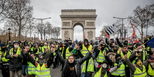 Francezi cântă în timpul protestului vestelor galbene pe Champs-Elysées lângă Arcul de Triumf la Paris Franţa FOTO Guliver / Getty Images / Chris McGrath