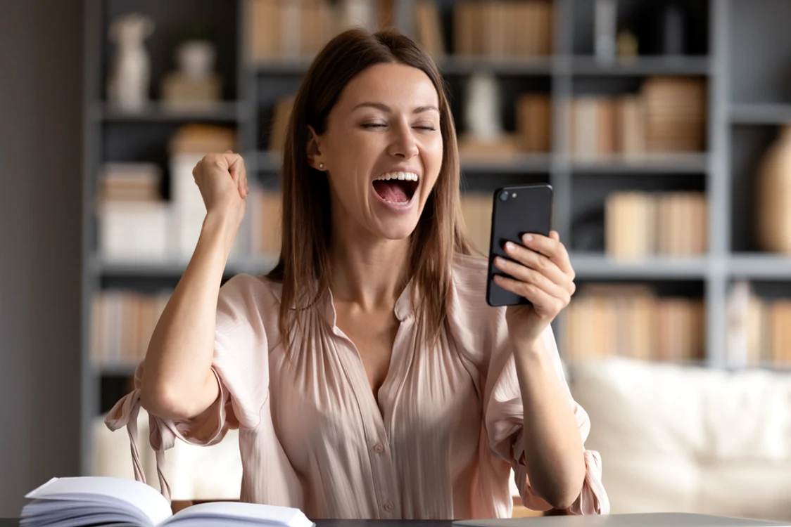 Femeie fericita privind spre telefon JPG