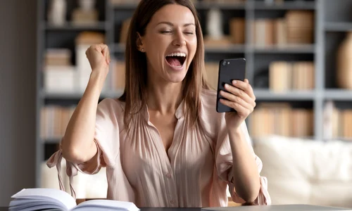 Femeie fericita privind spre telefon JPG