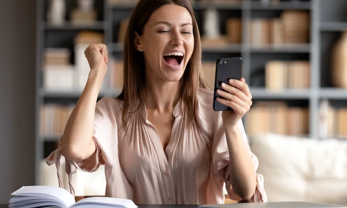 Femeie fericita privind spre telefon JPG